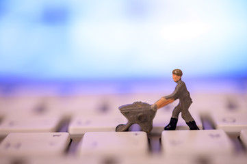 Miniature Worker model cleaning computer's dirty keyboard for hygenic, medical, clean purpose