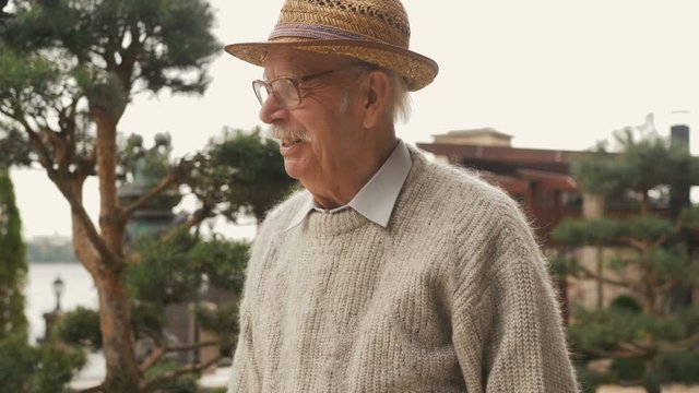Elderly man walks near nursing home care. Old Retired Man Walking in Nature Face Close Up- Healthy Lifestyle Elderly