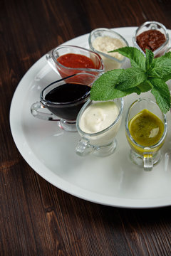 sauces in bowls on a dark wooden background. menu for catering