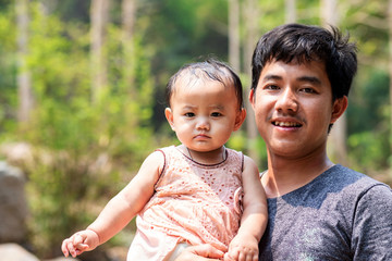Asian man carrying his daughter outdoor, Half body shot portrait dad and daughter