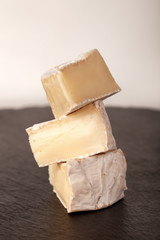 Camembert cheese is cut into pieces and whole.