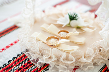 Pair of golden wedding rings in the white basket