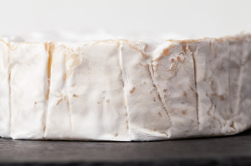 Camembert cheese is cut into pieces and whole.