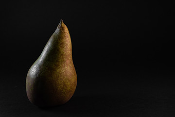 Fresh, sweet and juicy isolated pear on the dark, black background.