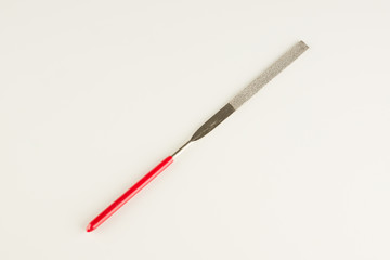 file with a long working part and a red dielectric handle