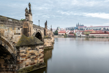 Charles Bridge and the river with the Castle and the Cathedral of St. Vitus in the background in Prague, Czech Republic.
