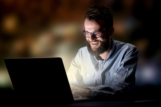 Young handsome businessman working late at night in the office