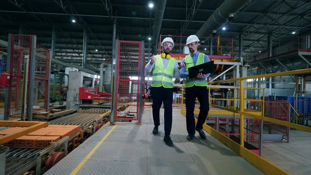 Male engineers work in a modern factory.