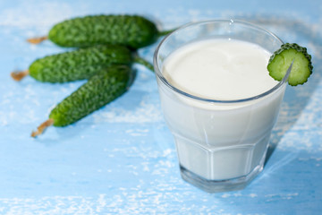 Ayran, homemade yogurt drink kefir, lassi with cucumbers - healthy summer refreshing cold drink on blue, copy space.