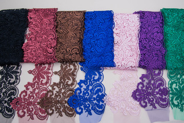  lace on white background studio. thin fabric made of yarn or thread. a background image of ivory-colored lace cloth. Red, green, brown, blue, pink, violet, black lace on beige background.