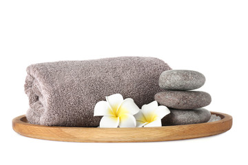 Wooden tray with towel, spa stones and flowers isolated on white