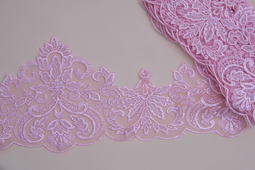 Texture lace fabric. lace on white background studio. thin fabric made of yarn or thread. a background image of ivory-colored lace cloth. Pink lace on beige background.