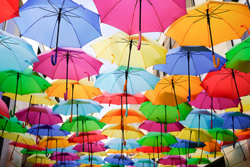 Fototapeta na wymiar Colorful umbrellas multicolored rainbow hung over the street