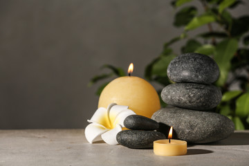 Composition with candles and spa stones on grey table. Space for text