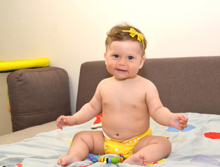 Little fun girl sits on the couch