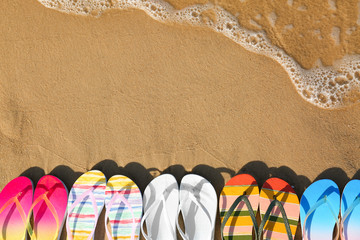 Flat lay composition with flip flops on sand near sea, space for text. Beach accessories © New Africa