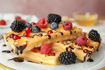 Delicious waffles with fresh berries served on table, closeup