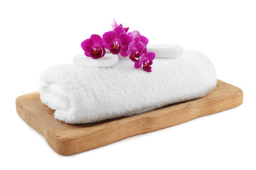 Board with orchid, spa stones and towel on white background