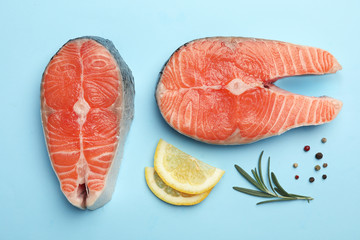 Flat lay composition with salmon steaks on blue background