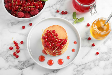 Tasty pancakes with berries on white marble table, flat lay
