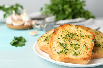 Slices of toasted bread with garlic and herbs on blue wooden table, closeup. Space for text