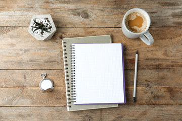 Flat lay composition with office stationery and cup of coffee on wooden table. Space for design