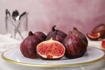 Plate with tasty ripe figs on light grey marble table