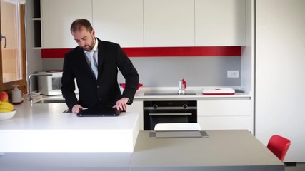 Cheerful businessman dancing in the kitchen. Drinking wine at the end of the evening after work