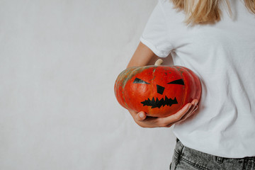 Halloween pumpkin. Woman holding a scary face pumpkin. Happy Halloween party holiday. Celebrate...