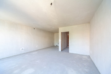New empty room under construction. Plaster walls. New home. Concrete walls. Interior renovation.