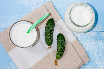 Ayran, homemade yogurt drink, kefir, lassi with cucumbers - healthy summer refreshing cold drink on a blue background. The concept of weight loss and healthy eating.