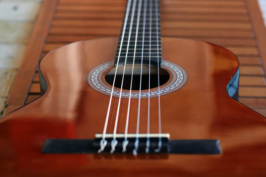 Music Concept: Brown acoustic guitar on a wooden background.