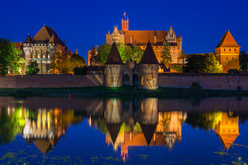 Fototapeta premium Malbork castle over the Nogat river at night, Poland