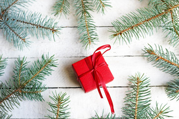 winter background red present and green fir dranches on white wood