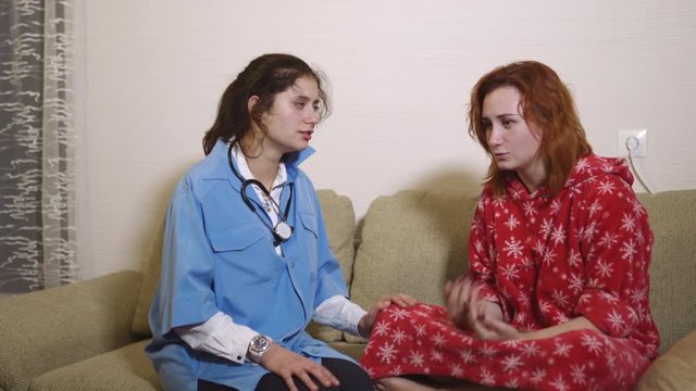 Ill patient with flu called young doctor for examination and checkup - Sick caughing woman getting her diagnosis by an ambulance summon - Stethoscope on the neck of blue uniform