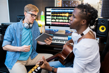 Young singer or musician of African ethnicity and his colleague recording song
