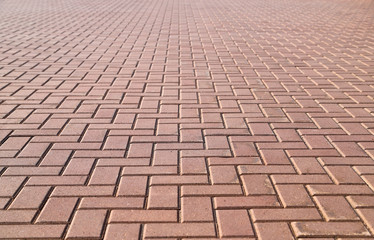 Sidewalk paved with square and rectangular red tiles in perspective. Photo with selective focus