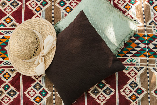 Pillows and a hat on colorful rug