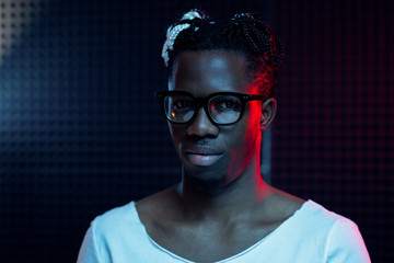 Young man of African ethnicity standing in front of camera in isolation