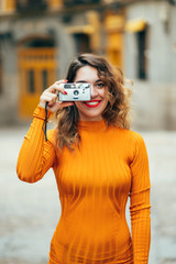 Pretty woman taking photos with camera reel in streets of Madrid Spain