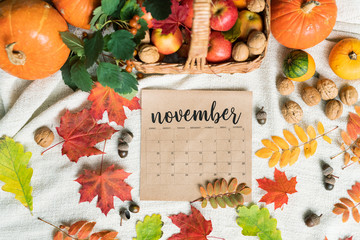 Top view of November calendar surrounded by harvest and autumn leaves