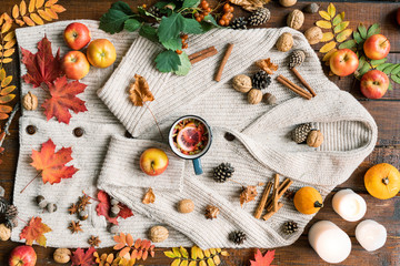 Autumn composition of ripe fruit, leaves, spices, candles, drink, nuts and cones