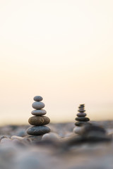 Balanced stone pyramid on pabbles beach with sunset. Zen rock, concept of balance and harmony.