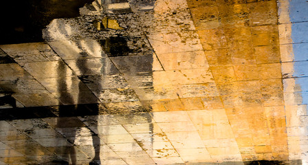 Blurry abstract shadow silhouette reflections of two people walking on city street