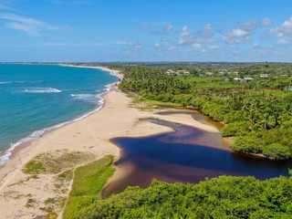 Aerial view of river merging to tropical ocean
