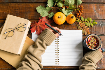 Female student hands with pen and hot drink making notes in copybook