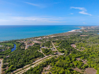 Fototapeta na wymiar Aerial view of Praia Do Forte coastline town with blue ocean