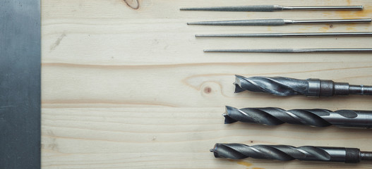 Drills on wood, files on a wooden background. Top view with copy space. Flat lay
