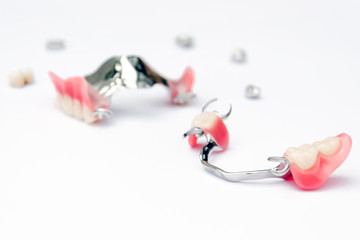 a set of removable clasp prostheses with supporting metal-ceramic and metal crowns on the upper and lower jaws on white background