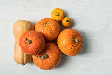 Pile of large orange pumpkins and two yellow small ones over white background